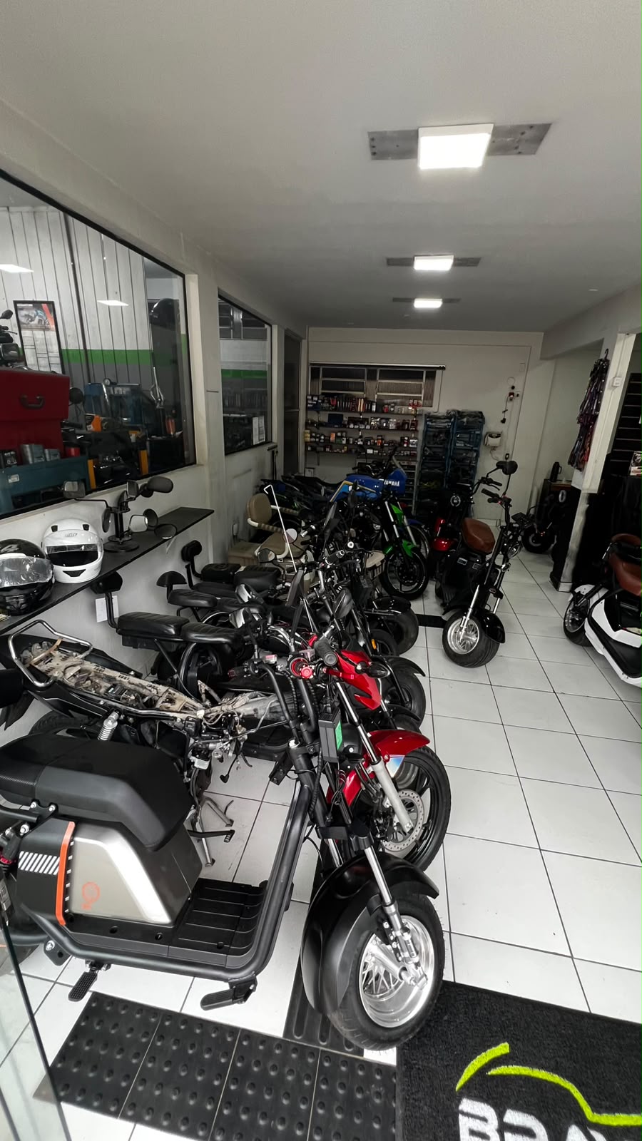 Showroom da Brayan Motos com scooters elétricas, capacetes e acessórios