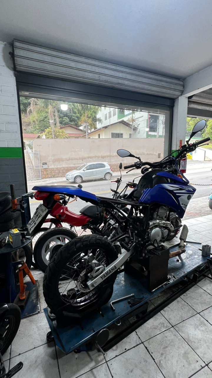 Yamaha XTZ azul sobre o elevador da oficina Brayan Motos